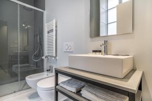 Baño blanco con lavabo y aseo en Oriana Homèl Torino en Turín