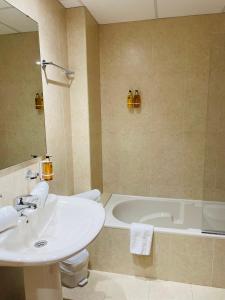 uma casa de banho com um lavatório e uma banheira em Hotel Venteo em Platja d'Aro