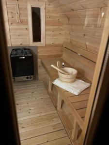 a small wooden sauna with a stove and a microwave at Abigél Vendégház Keszthely in Keszthely
