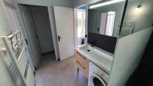 une salle de bain avec un lavabo et une machine à laver dans l'établissement VILLA MARILOU 5 personnes, à La Faute-sur-Mer