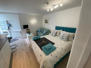 a bedroom with a bed and a living room at Sweet Caroline - luxury studio stone’s throw from Mousehole harbour in Mousehole
