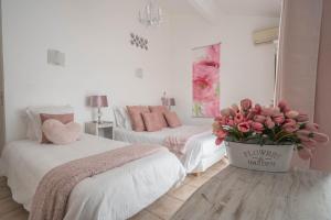 a bedroom with two beds and a vase of flowers at Hôtel Le Méditerranée in Hyères