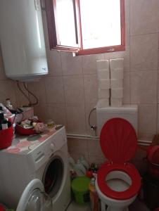 a bathroom with a washing machine with a red lid at Rooms Apartment Durmitor in Žabljak