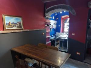 a dining room with a wooden table and red walls at Loft 70 in Montescudaio