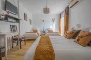 a white bedroom with two beds and a desk at Hôtel Le Méditerranée in Hyères