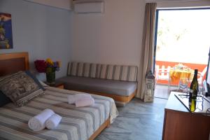 a hotel room with a bed and a table and a window at Marina Sands in Agia Marina Nea Kydonias