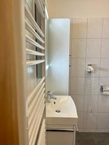 a white bathroom with a sink and a shower at Pension Sommerauer in Hallein