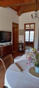a dining room with a table and a television at Casa Belo Horizonte in Lourinhã