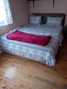 a bed with a red blanket on top of it at Rooms Apartment Durmitor in Žabljak