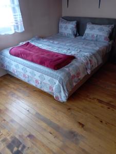 a bed sitting on top of a wooden floor at Rooms Apartment Durmitor in Žabljak