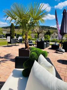 eine Terrasse mit einer Palme, einem Tisch und Stühlen in der Unterkunft Maxhof Trier in Trier