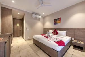 a bedroom with a large bed and a bathroom at ROSASTAYS Gurugram Golf Course in Gurgaon