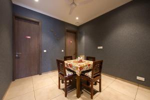 comedor con mesa, sillas y puerta en ROSASTAYS Gurugram Golf Course, en Gurgaon