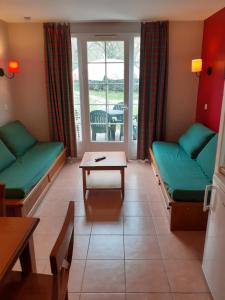 una sala d'attesa con divani verdi e tavolo di Superbe duplex a Monflanquin