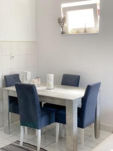 a dining room table with blue chairs and a mirror at Apartmani Milan in Trebinje +11 photos