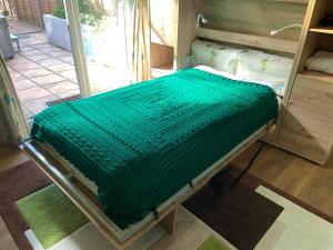 a green blanket on a bed in a room at The Barn in South Hayling