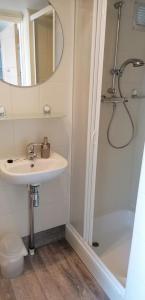 a bathroom with a sink and a shower with a mirror at Vakantiewoning met terras vlakbij strand en centrum in Zoutelande