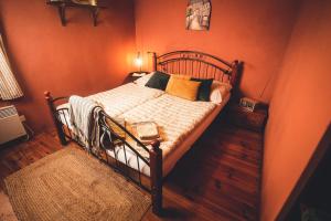 1 dormitorio con 1 cama con paredes de color naranja en Pension Cert a Kaca, en Český Krumlov