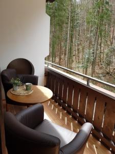 Habitación con mesa, sillas y ventana en Almara - 2 bedroom - 60 m2 - Family Apartment, en Bad Goisern