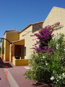 ein Haus mit lila Blumen auf der Seite in der Unterkunft Résidence l'Oustal des Mers in Gruissan