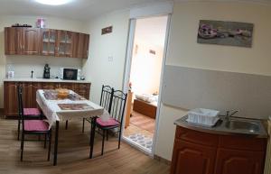 Akhilleus vendégház في نيرغهازا: مطبخ وغرفة طعام مع طاولة وكراسي