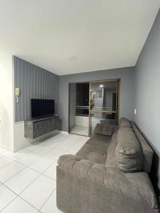 Apartamento Condominio Emilio Hinko - Beira Mar في فورتاليزا: غرفة معيشة مع أريكة وتلفزيون بشاشة مسطحة