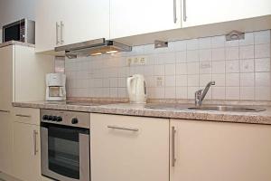 cocina con fregadero y encimera en Fischerhus _ Wohnung 3 en Cuxhaven