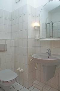 Baño blanco con lavabo y aseo en Fischerhus _ Wohnung 3 en Cuxhaven