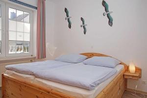 1 dormitorio con 1 cama con cabezas de pescado en la pared en Fischerhus _ Wohnung 3 en Cuxhaven