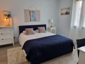 Saint-Médard-dʼEyransVilla Géna的卧室里有一张大床，上面铺着蓝色毯子
