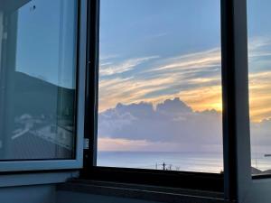 a window with a view of the ocean and the sky at Casa Às Sete in Angra do Heroísmo