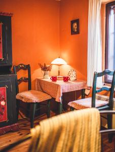 an orange room with a table with chairs and a lamp at Pension Cert a Kaca in Český Krumlov