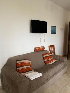 a bedroom with a bed with a television on the wall at Emilù a mare in Schiavonea