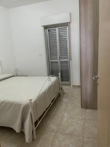 a bedroom with a bed and a door leading to a doorway at Emilù a mare in Schiavonea