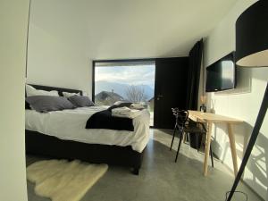 um quarto com uma cama e uma grande janela em Chalet Evolena em Guillestre