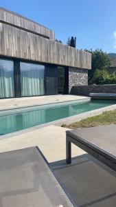 a swimming pool with a bench in front of a building at Chalet Evolena in Guillestre