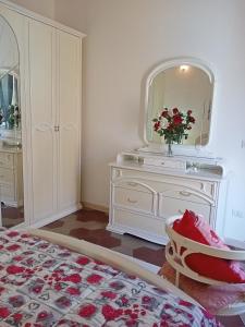 a bedroom with a white dresser and a mirror at Appartamento vacanze Le rose in Bosa