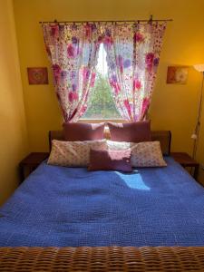 a bedroom with a blue bed with a window at Gartenapartment Storchenblick in Weiden am See