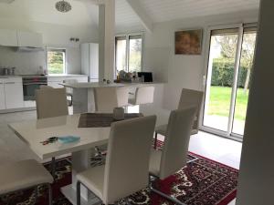 una cucina e una sala da pranzo con tavolo e sedie di Maison moderne 8 personnes, jardin, parkings, fibre THD, plage 5 min a Vannes
