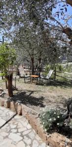 Appartamento Ulivo في فينالي ليغوري: حديقة بها كرسيين وطاولة وأشجار