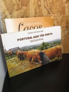ein Poster für eine Ranch mit Kühen auf einem Feld in der Unterkunft Rústico T1 no centro cidade in Guarda