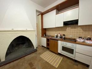 a kitchen with a fireplace in the middle of it at Casale Colle dei Pini in Casaccia