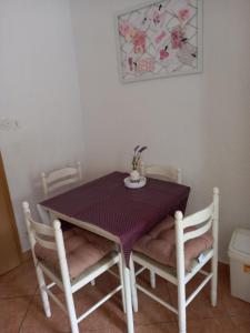 a table and two chairs with a purple table and a table and chairs at Studio Ana in Selce