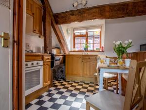 een keuken met houten kasten en een geruite vloer bij Pass the Keys Quaint 1 bedroom cottage in Church Stretton in Church Stretton