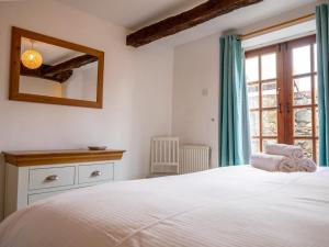 een slaapkamer met een wit bed en een raam bij Pass the Keys Quaint 1 bedroom cottage in Church Stretton in Church Stretton