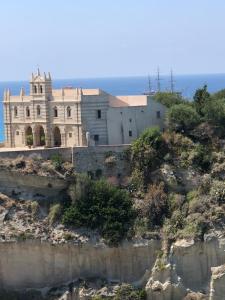 a building on the side of a cliff next to the water at Monolocale Love Loft in Tropea