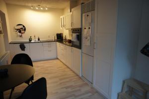 a kitchen with white cabinets and a table and a table and chairs at 87 Østergade (id. 051) in Esbjerg