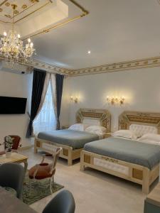 a bedroom with two beds and a chandelier at Chambre Familiale Maison de L'Église du Couvent in Narbonne
