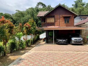 ein Haus mit einem davor geparkt in der Unterkunft Villa Ainun in Pasirmuncang 1