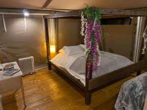a bedroom with a canopy bed covered in flowers at Beautiful Lakeside Safari Lodge in Bruton